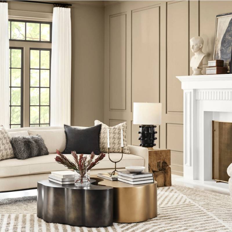 Sherwin-Williams Universal Khaki SW 6150 warm neutral paint color in a modern living room with soft beige walls, white fireplace, and layered textures