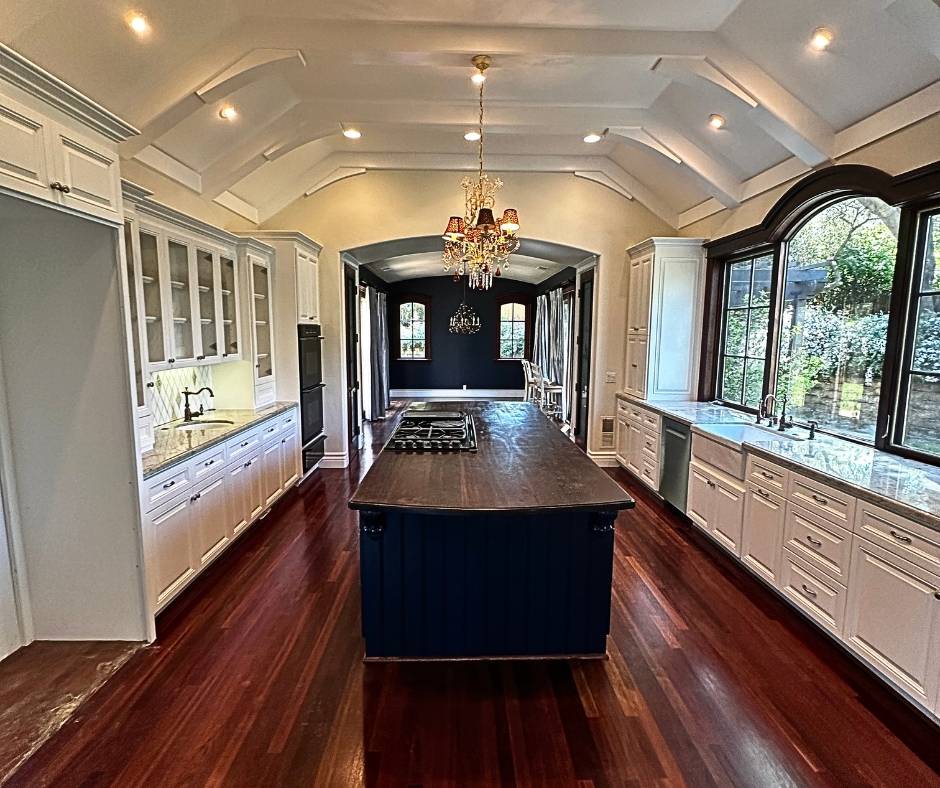 Custom kitchen cabinet painting project in Loomis, California featuring white perimeter cabinets and a dark painted island, professionally completed by Trico Painting.