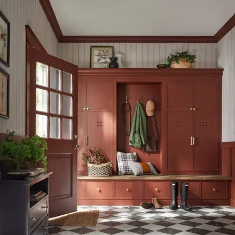 PPG Warm Mahogany PPG1060-7 rich brown-red paint color on built-in mudroom cabinets with warm natural light and classic tile flooring
